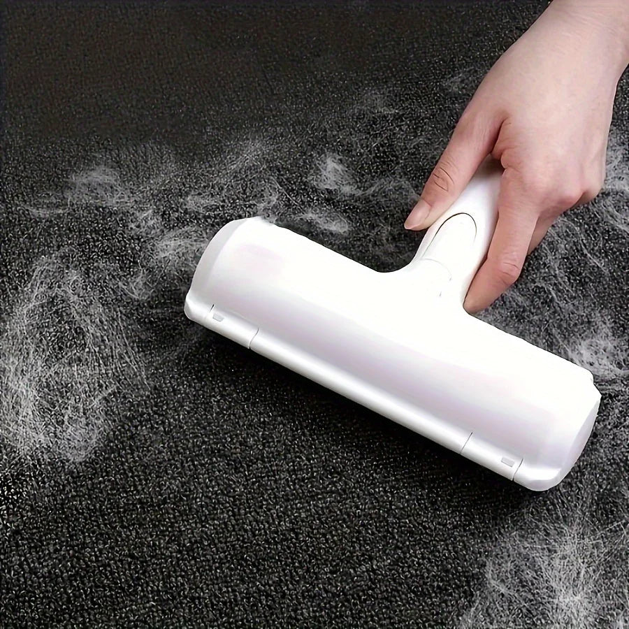 Brosse ramasse poils blanche tenue à la main sur tapis noir avec poils blancs visibles