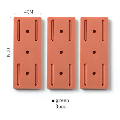 Trois plaques rectangulaires en silicone orange de 10x4 cm avec perforations et fentes