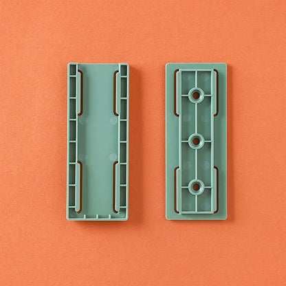 Deux plaques rectangulaires en plastique vert menthe sur fond orange, vue de dessus